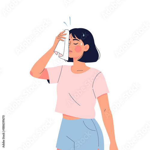 Woman wiping sweat from forehead while standing indoors  