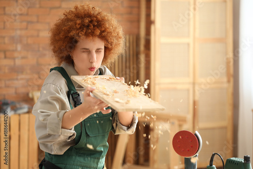 Young female carpenter blow...