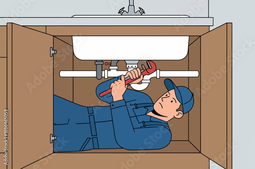 Plumber working under sink with adjustable wrench