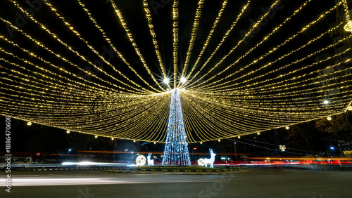 Long exposure urban cityscape with Christmas lights over roundabout at night.