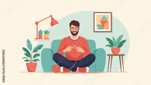 Man sitting on couch knitting a red garment with yarn ball