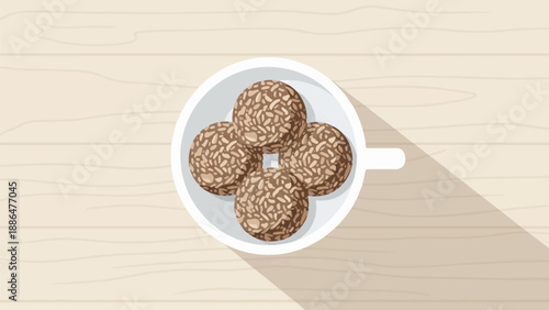 Overhead view of a cup holding four round, textured snacks on a wooden surface