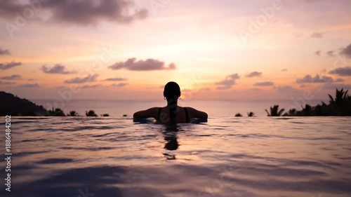Wallpaper Mural Woman enjoying a beautiful sunset from an infinity pool, with a stunning view of the ocean and a colorful sky. Torontodigital.ca