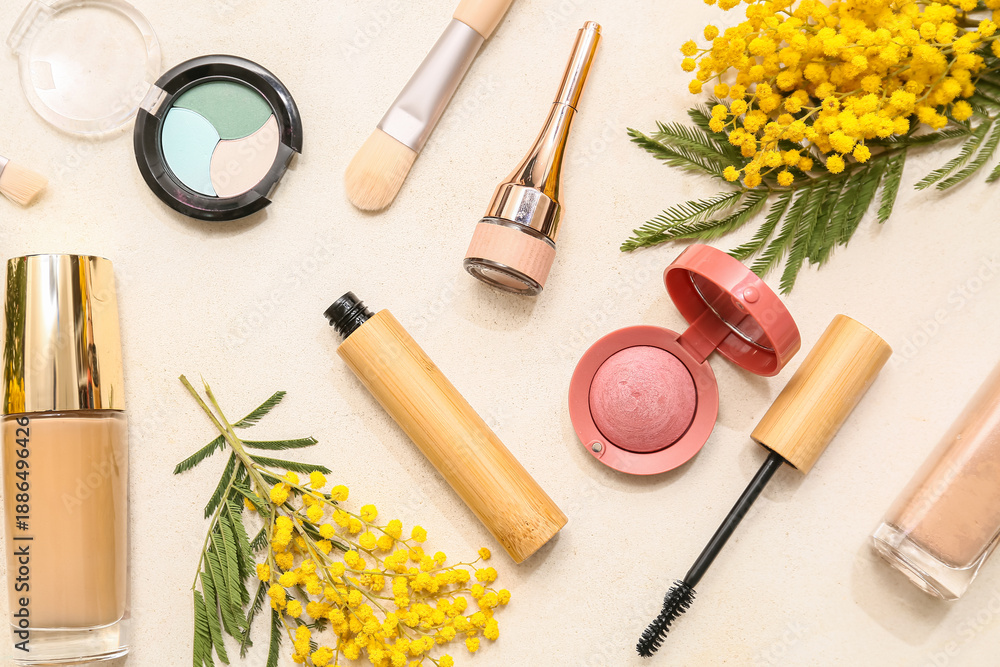 Naklejka premium Decorative cosmetics and mimosa flowers on white background