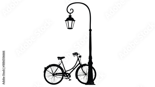 A bicycle stands beside a streetlamp in silhouette