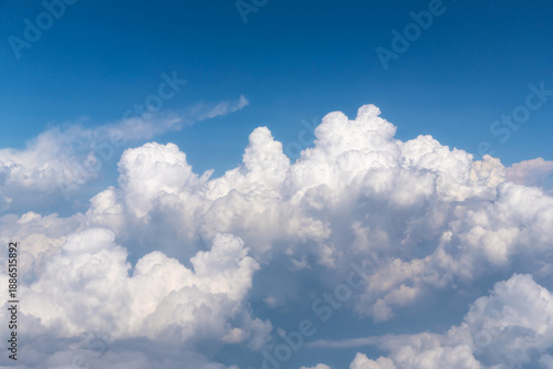 Принти на полотні Close up of dramatic white fluffy clouds in the blue sky viewed from a high altitude flight