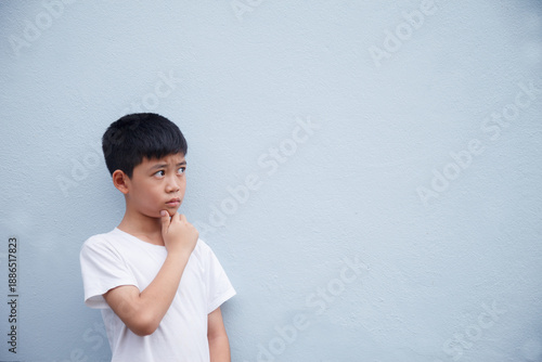 The boy is deep in thought, against a gray background with space for text.