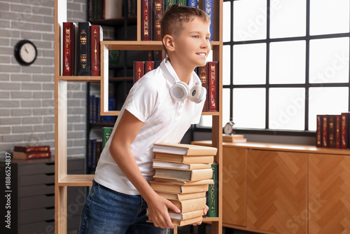 Teenage boy with stack of b...