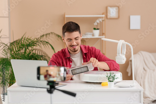 Young male blogger recordin...