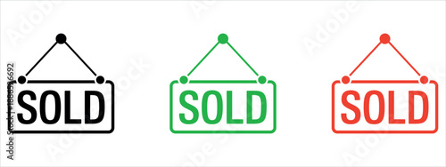 Set of colorful SOLD signs hanging from strings in black green red.
