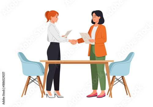 Two businesswomen exchanging documents at a wooden desk with blue chairs in office setting with