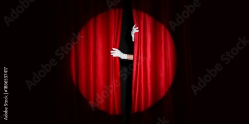 Foto Female hands in white gloves opening red curtains on dark background