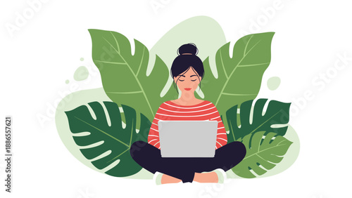 Young woman sitting cross-legged while working on a laptop laptop surrounded by large tropical green leaves.
