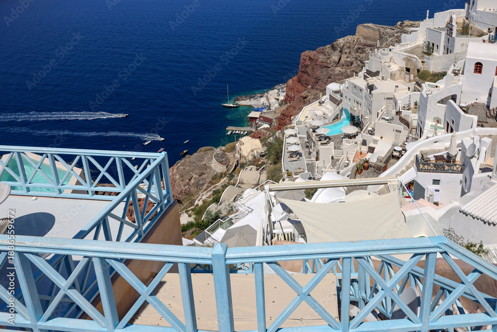 Fototapeta premium Whitewashed houses with terraces and pools and a beautiful view in Oia on Santorini island, Greece