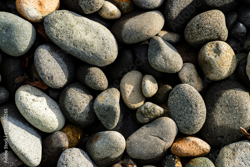 natural river pebbles stone texture background with earth tones