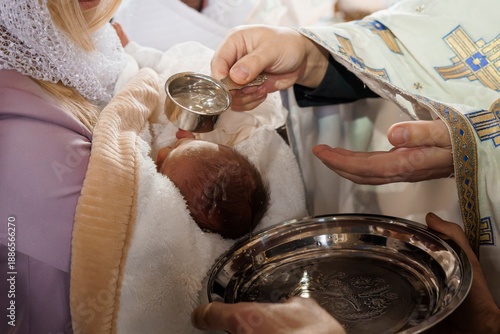 Orthodox Christian Baptism Ceremony with Priest Pouring Water on Infant Baby in Church Setting