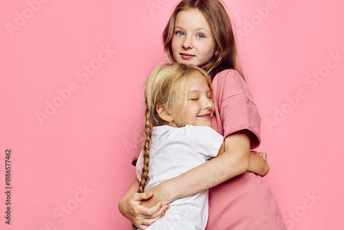 Fényképezés Two young girls embracing against a pink background