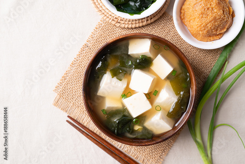 Obraz na plátně Top view of healthy Japanese miso soup with soft tofu and seaweed in a wooden bo