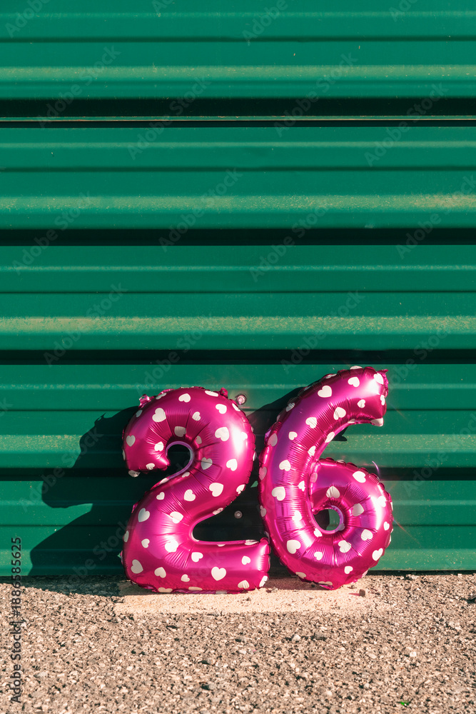 Naklejka premium pink balloons forming the number 26 against a wall