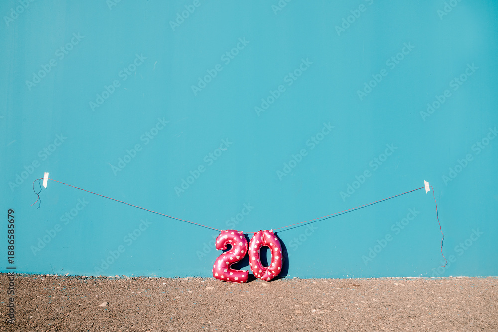 Naklejka premium the number 20 hanging against a wide blue wall