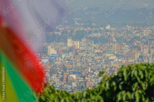 CLOSE UP: Colorful prayer flags flutter over the city of Kathmandu in the back.
