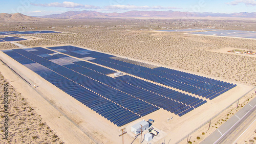 AERIAL: Barren landscape surrounds a large farm of solar panels in California.