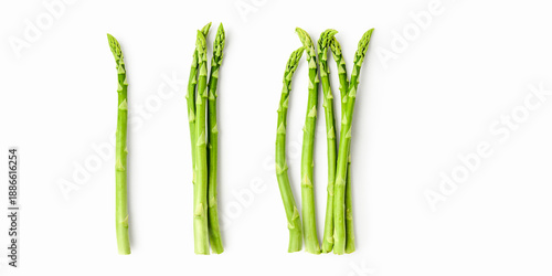 Fresh green asparagus composition isolated on white background. Minimalist food layout with single, three and five spears, clean copy space for healthy cooking, branding and seasonal concepts