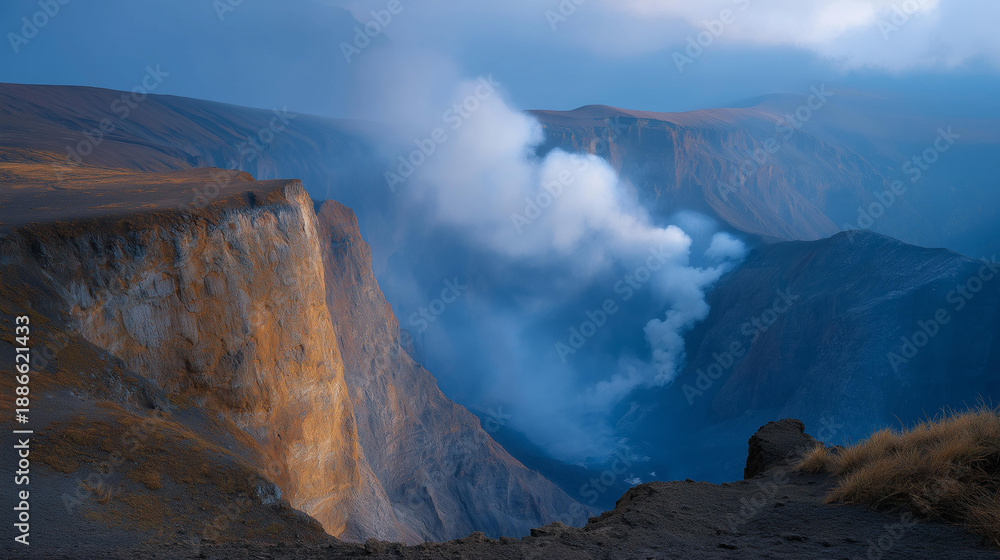 Naklejka premium A dramatic landscape featuring a volcanic crater with smoke, demonstrating the forces of nature at work, ideal for educational materials or publications focusing on the importance of understanding