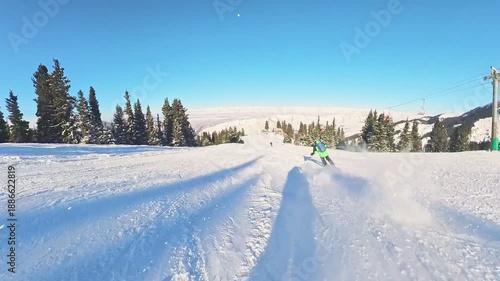 Skier skiing downhill in high mountains. Winter ski resort. Skiing. Snowboarding. Extreme winter sports in the mountains of Kyrgyzstan. Male alpine skier racing downhill on snowy slope.