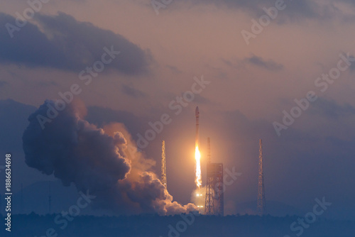 Quadro em tela Rocket launch at dawn with billowing smoke against clouded sky and big flames, m