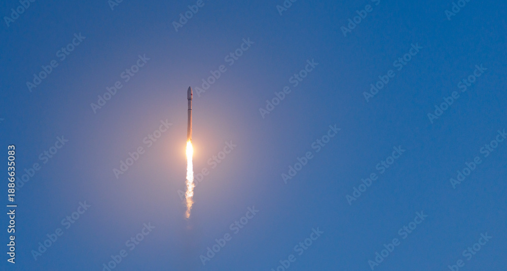 Fototapeta premium Rocket with satellites launch against clear blue sky at daytime, banner of concept aerospace program