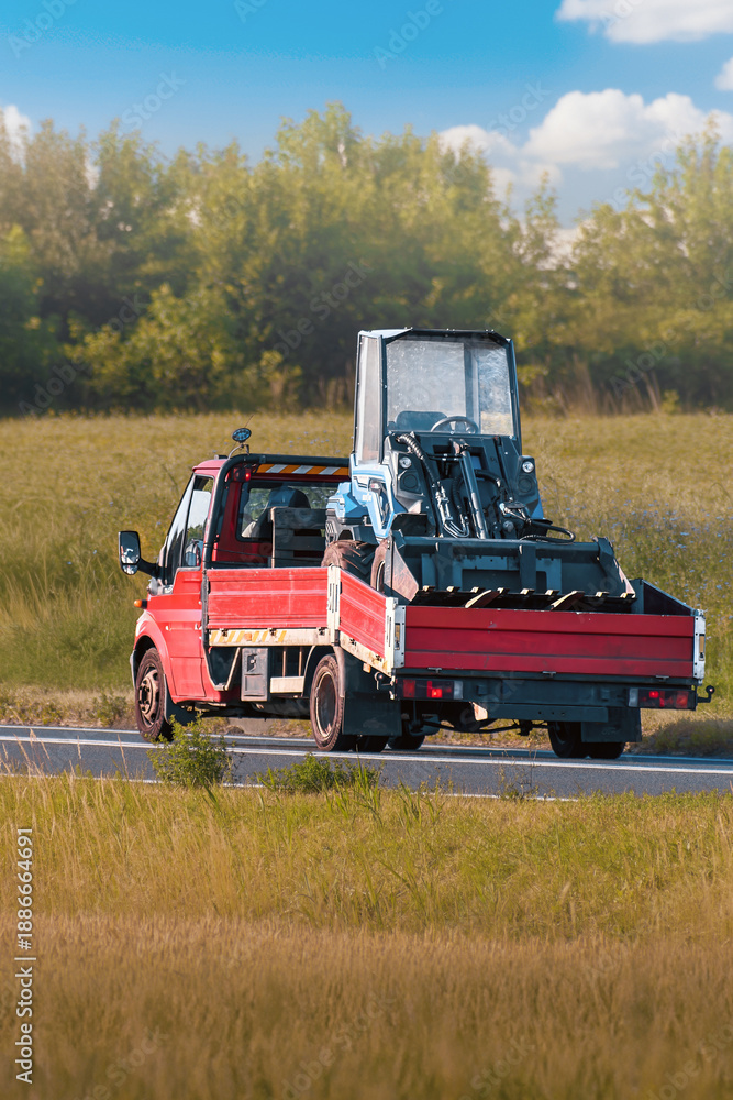 Fototapeta premium Flatbed trailers moving heavy construction vehicles