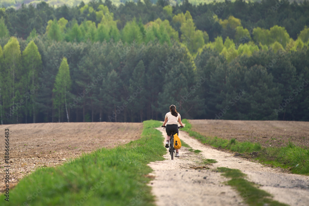 Obraz premium Back view of cyclist on country path