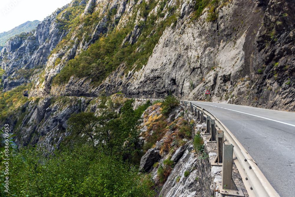 Fototapeta premium A mountain road winds along a rugged cliff, Montenegro