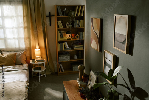Φωτογραφία Modern bedroom interior featuring bookshelf filled with books, framed abstract a