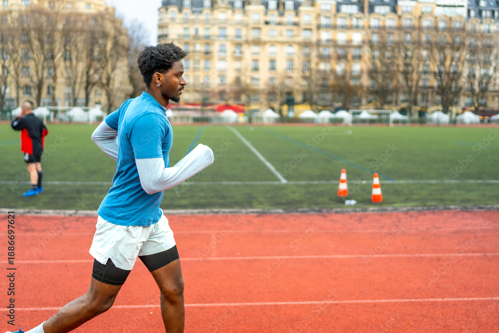Obraz premium Black man running on track in paris city