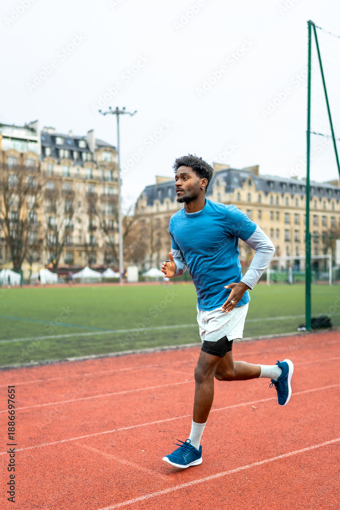 Obraz premium Male athlete running on a track in paris city
