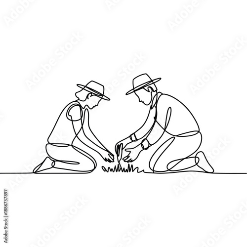 Two people kneeling building a small campfire with kindling shown