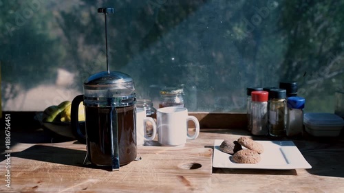 A still-life composition of coffee, snacks, and morning sunlight on wooden surface Cederberg, South Africa