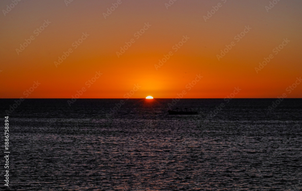 Naklejka premium Final rays of sunlight over the ocean