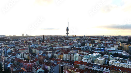 Obraz na plátne Drone aerial city panorama with dense rooftops and tall broadcast tower on the horizon, cool daylight over historic urban architecture, wide skyline background for travel and lifestyle