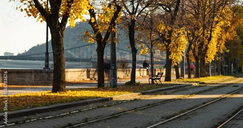 Budapest, Hungary - November 9, 2025: Timelapse, slide transition. Scenic autumn view of tram tracks along the tree-lined Danube embankment in Budapest Hungary
