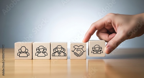 Businessman placing a wooden block with a handshake icon in a row of people icons symbolizing team collaboration, trust and successful business partnership.