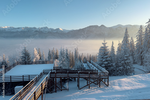 Wallpaper Mural Snow-covered landscape with wooden platforms and mountains in the background during winter Torontodigital.ca
