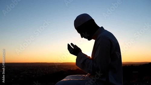 Man praying in contemplation at serene sunset landscape with flowing robes and peaceful surroundings in high definition video