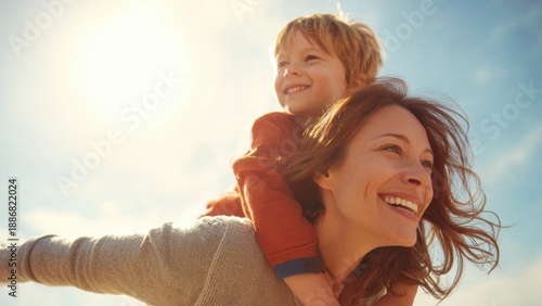 Mothers Day, Valentines Day, love holiday theme. A woman with a warm smile, cradling a child in her arms, against a backdrop of a bright blue sky illuminated by the sun.