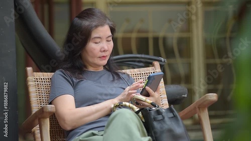 Wallpaper Mural Woman sitting outdoors using smartphone Torontodigital.ca