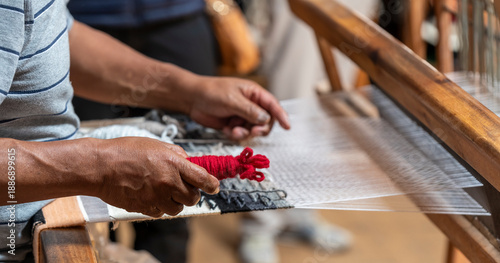 Indigenous man weaving textiles and fabrics, Otavalo, Ecuador.