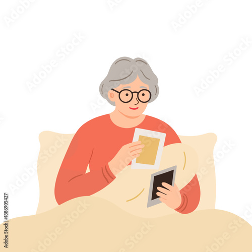 Elderly woman sitting in bed while looking at photo frames  