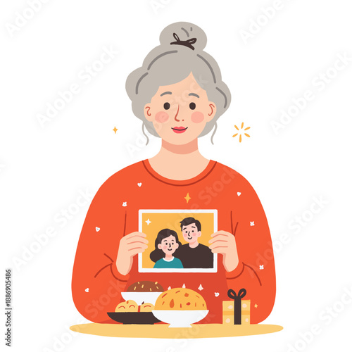 Elderly woman holding a photo of family while sitting at a table  